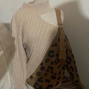 Leopard and tan sweater with buckle closer on left shoulder.
